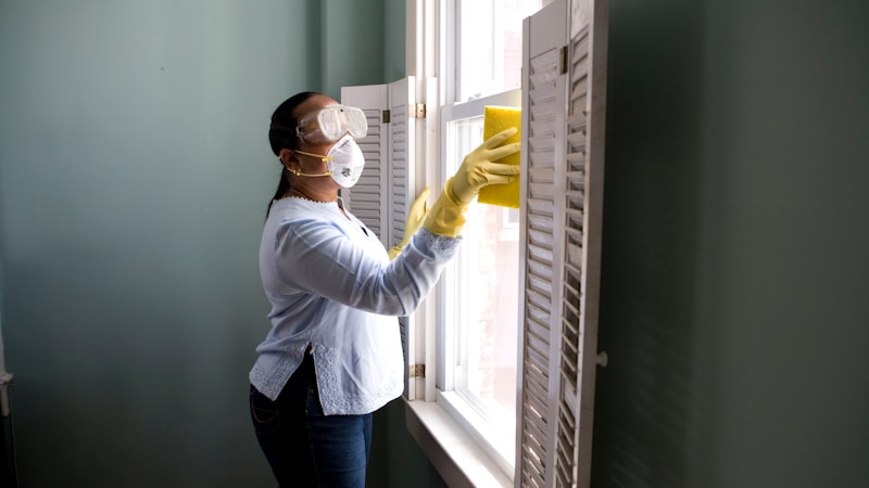 Person cleaning a window with a yellow sponge — windows since before the quakes